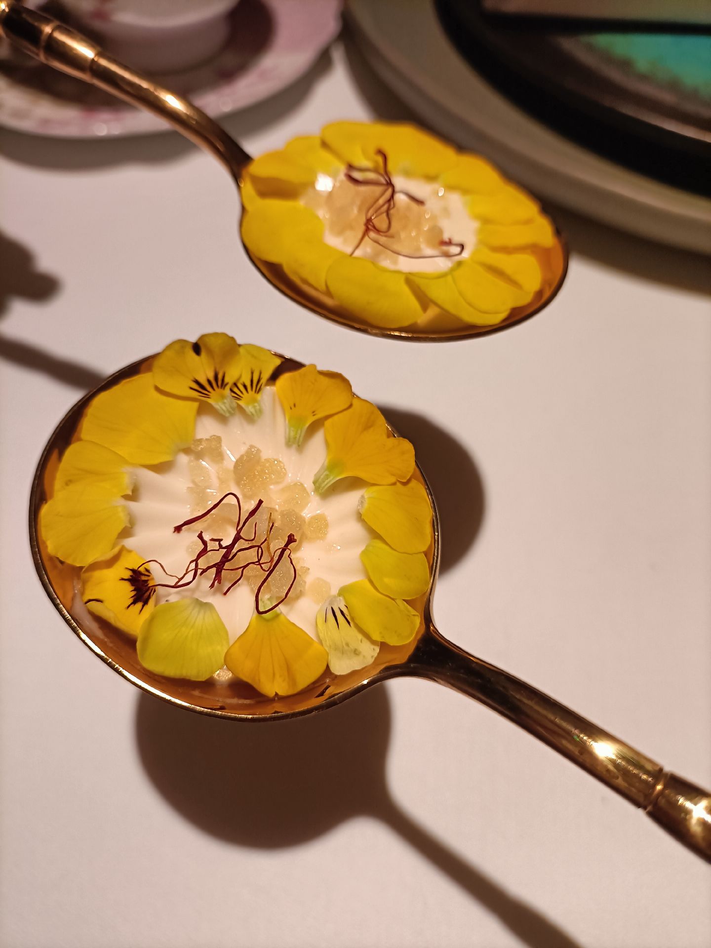 Saffron-infused makhan malai served on decorative spoons at Avatara, Dubai